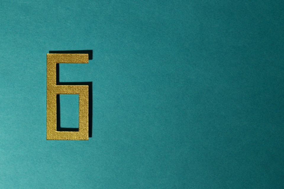 A number 6 cut from crafting paper against a dark turquoise background - signifying you ideally need 6 months to go through the remortgage progress