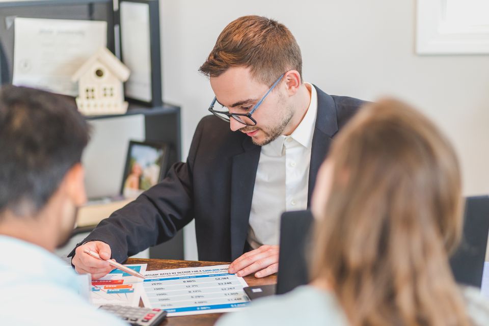 An estate agent sitting down to answer questions from a couple